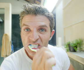 Man brushes teeth