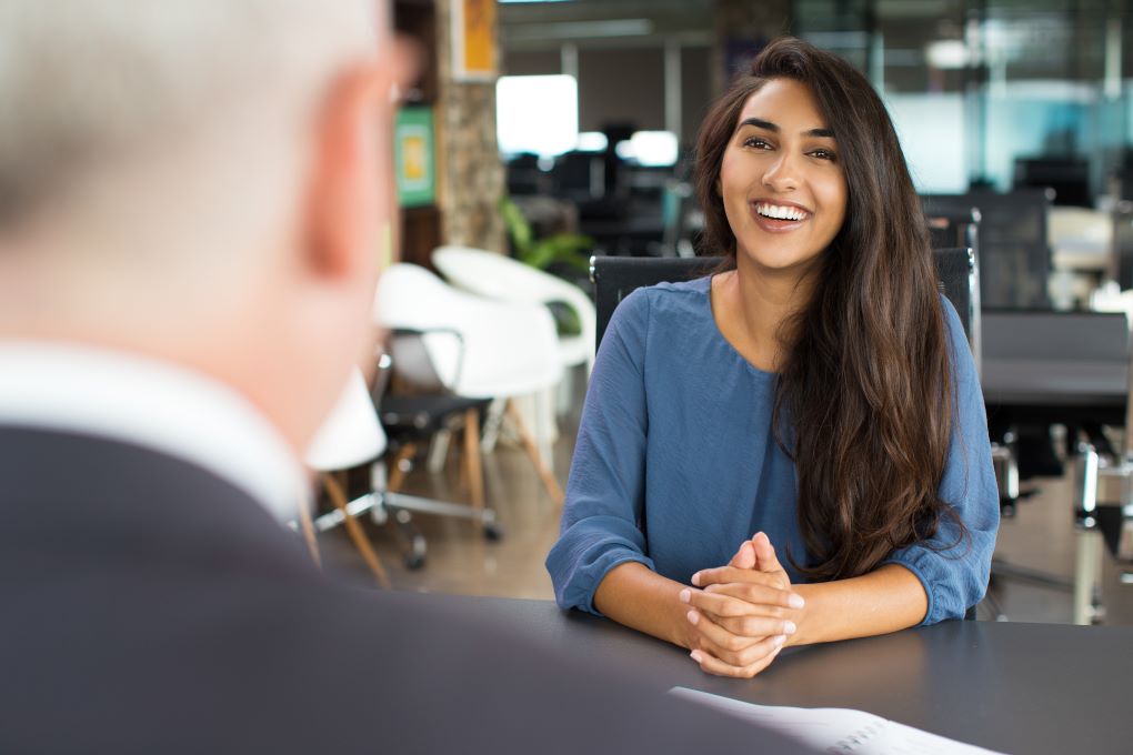 A woman smiling at a job interview.