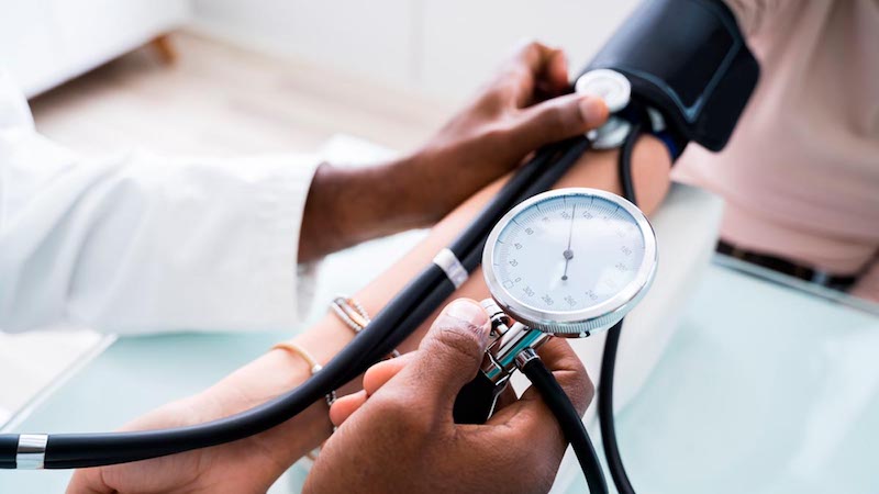 dentist taking a patient’s blood pressure